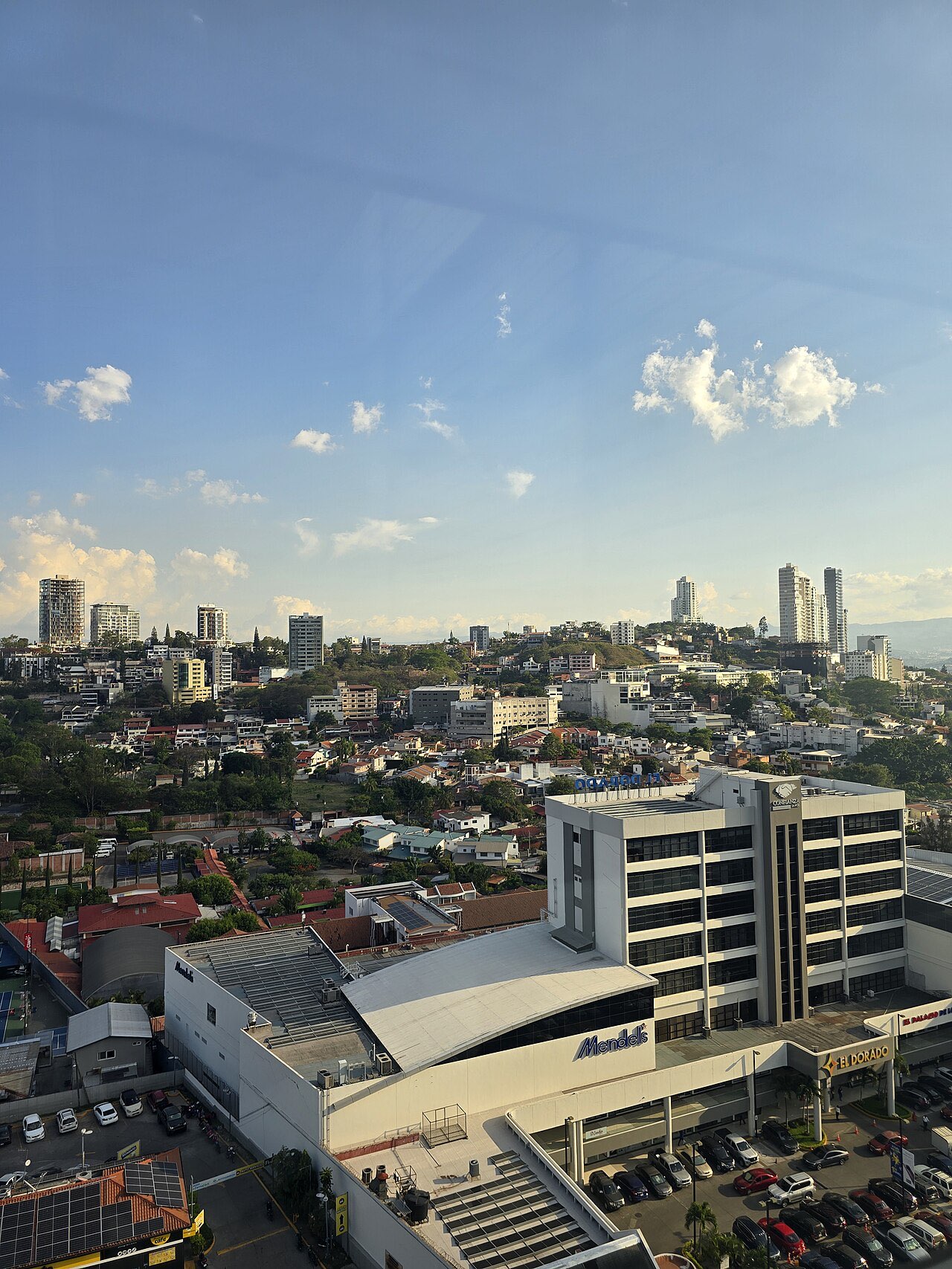 A view over Tegucigalpa at dusk showing low-rise neighbourhoods on hillsides with office towers on the skyline